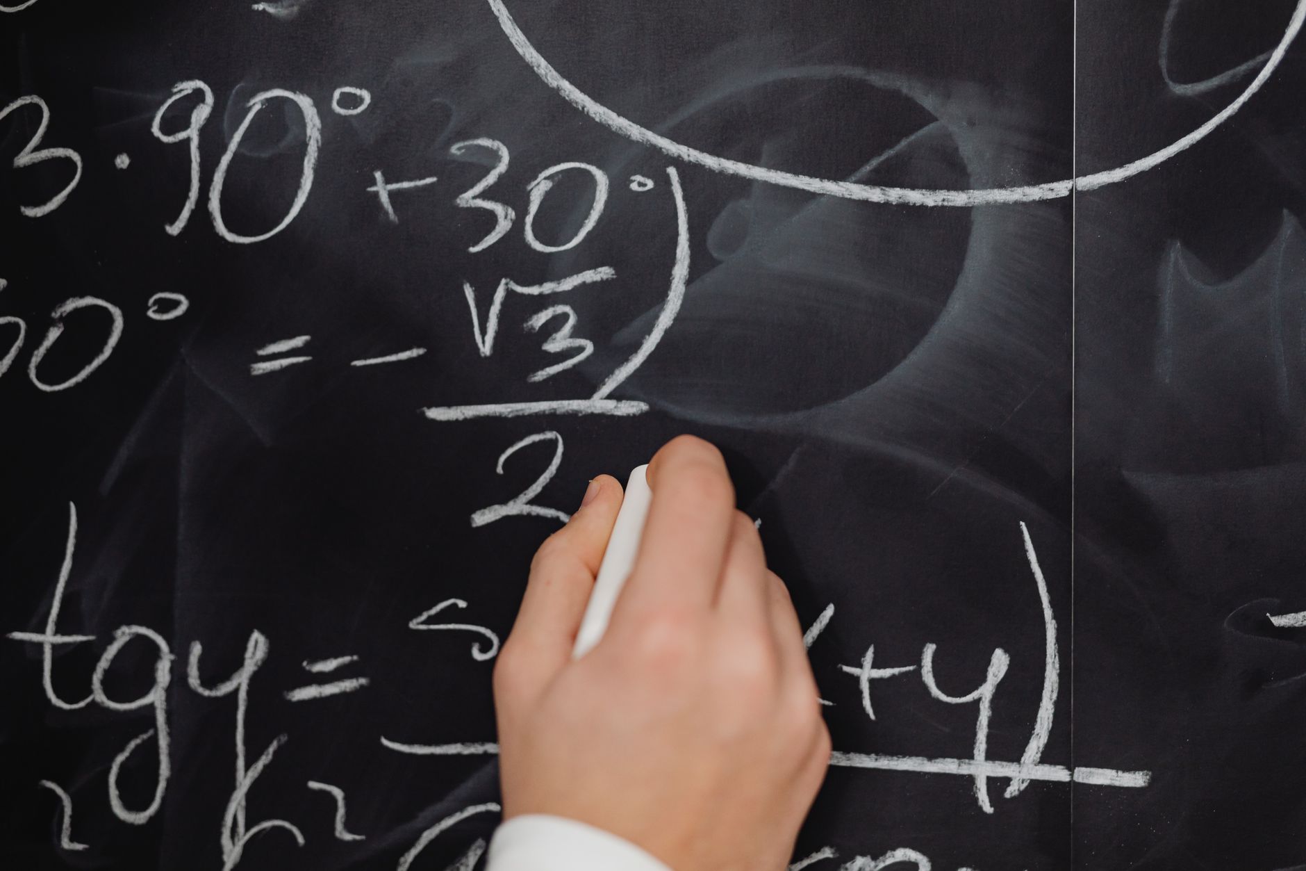 Complex mathematical equations written on a blackboard representing unsolved problems in fluid dynamics