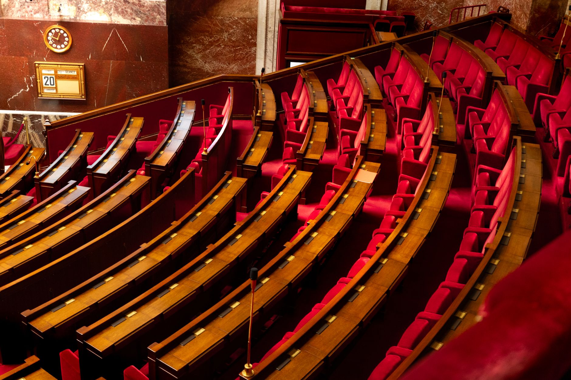 Empty United States Senate chamber with wooden desks and American flags