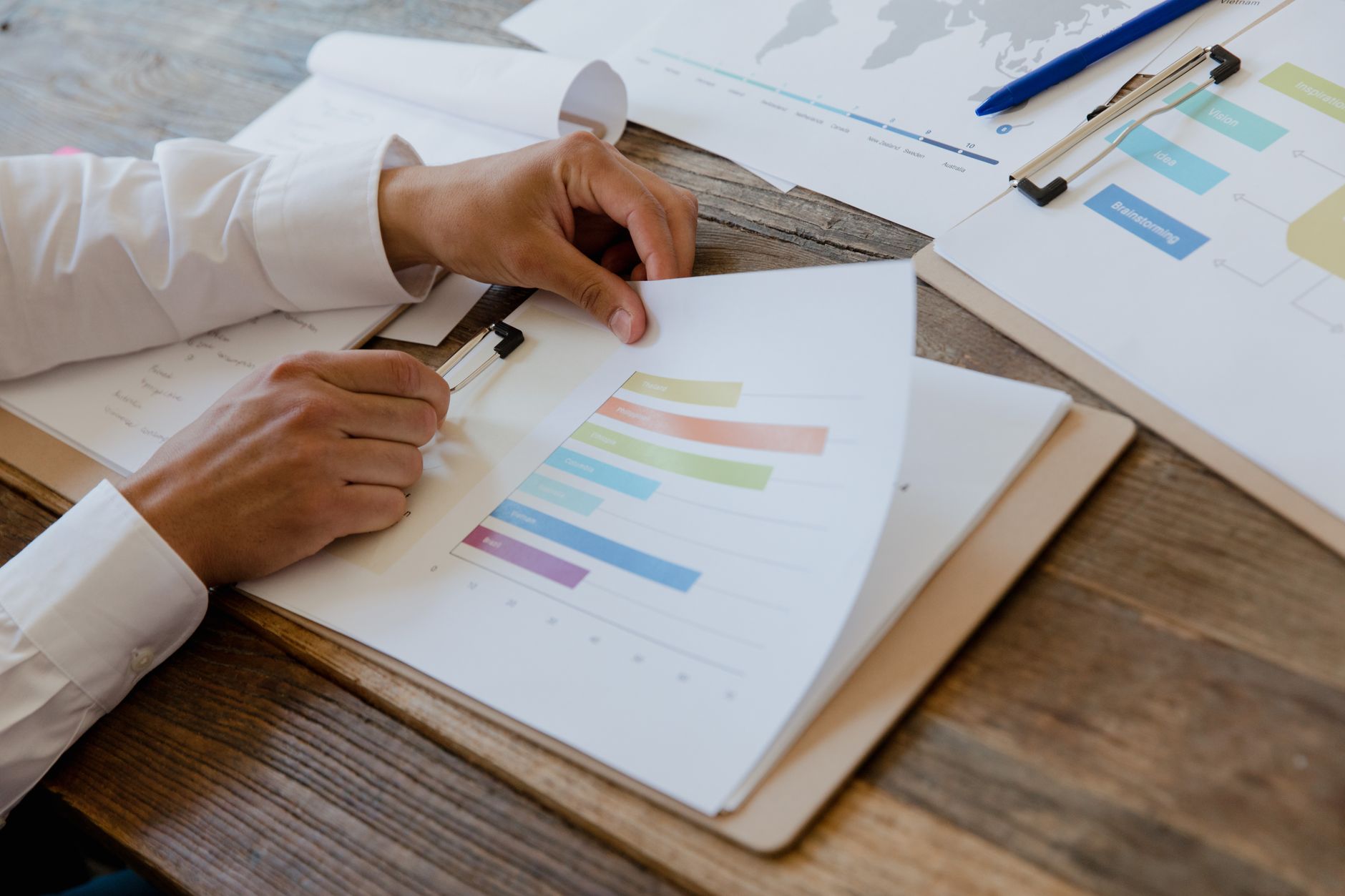 Analyst reviewing financial research documents and charts at a desk